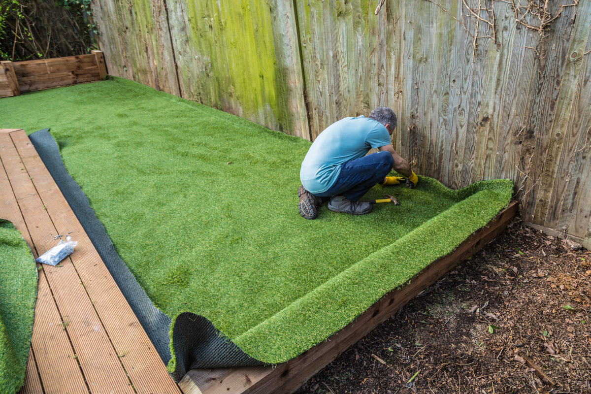 a picture of a person installing artificial turf